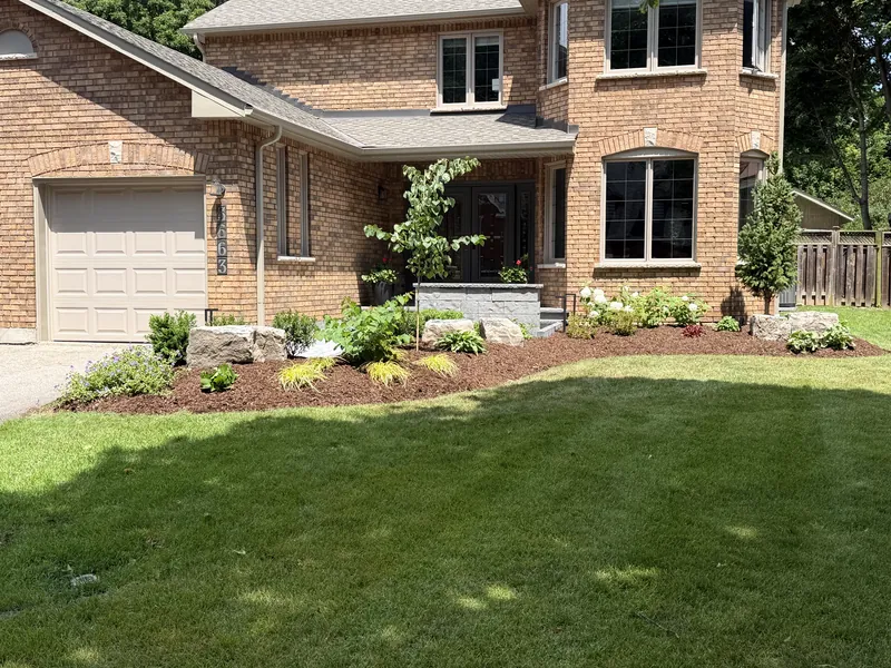 Finished planting wrapping the front of a brick house.